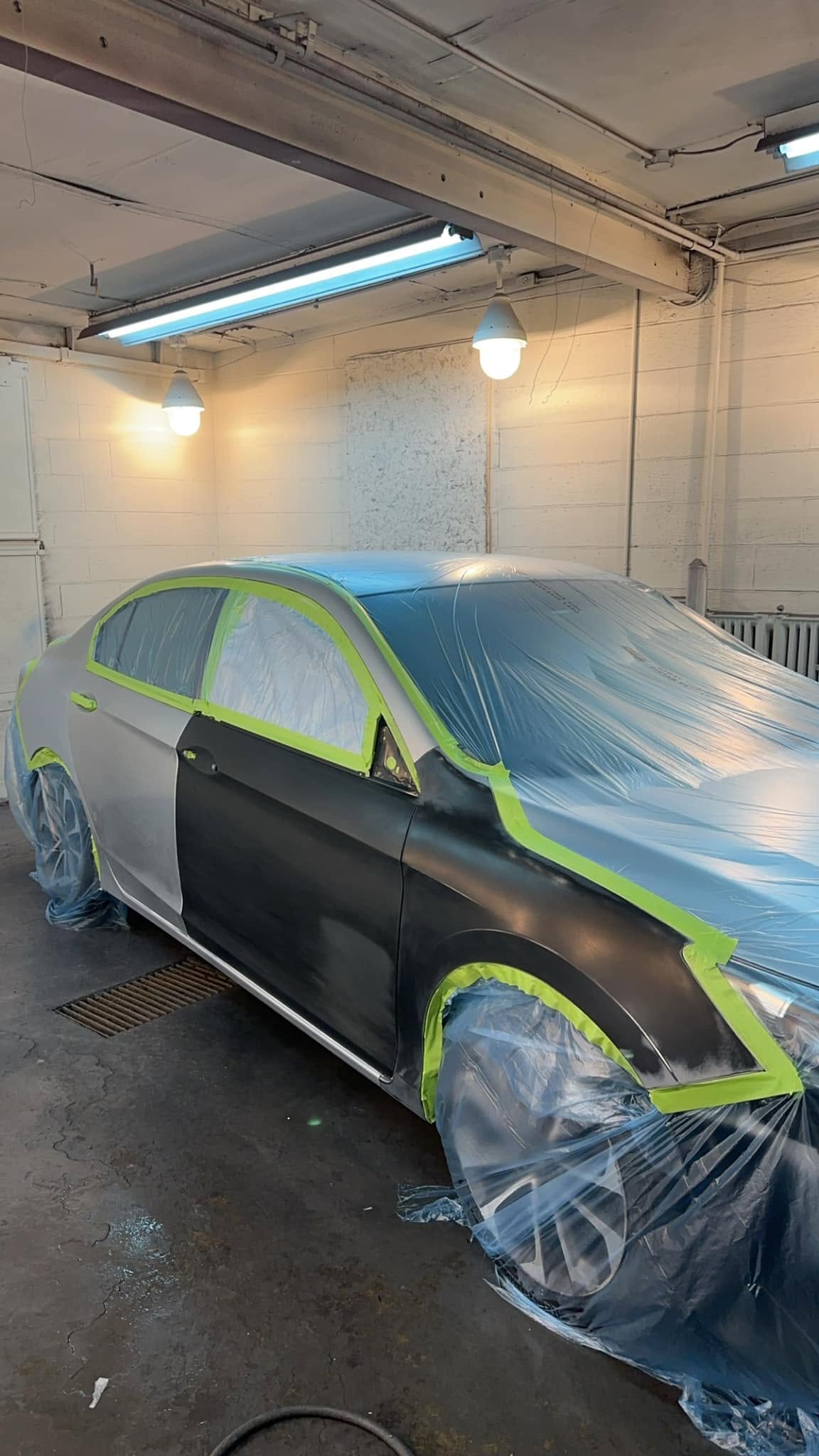 Vehicle mid paint job — color coat being applied in the booth